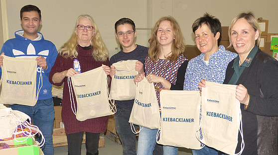 Die fleißigen Weihnachtshelfer von Kieback&Peter Mehrere Personen halten die Nikolausbeutel von Kieback&Peter in die Kamera.