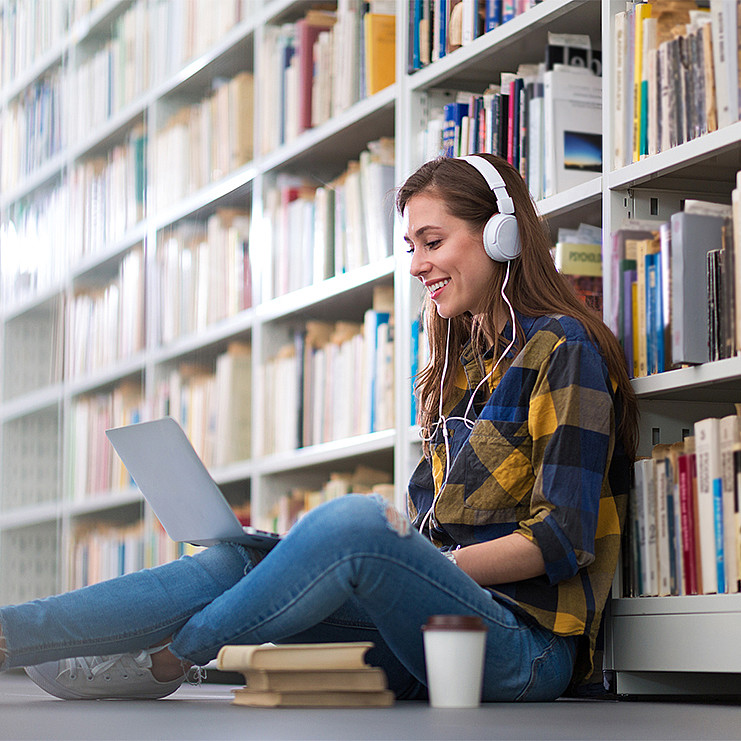Duales Studium - junge Studentin in der Bibliothek 